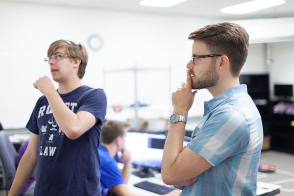 Two lab members watching an experiment in the robotics lab