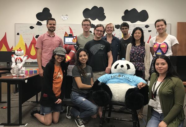 HEATlab group photo in the lab, with the lab's panda mascot wearing a HEATlab T-shirt